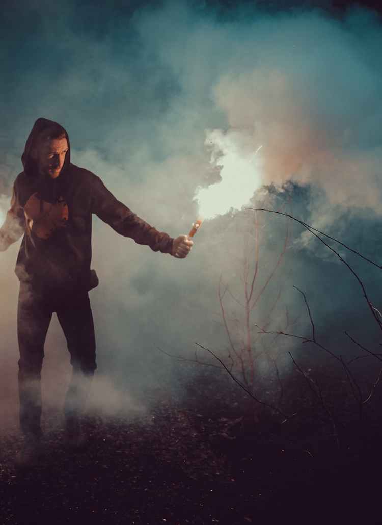 man in black hoodie holding fire
