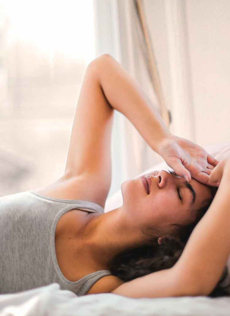 woman in gray tank top lying on bed