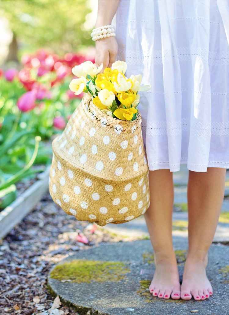 woman holding brown basket with yellow flowers