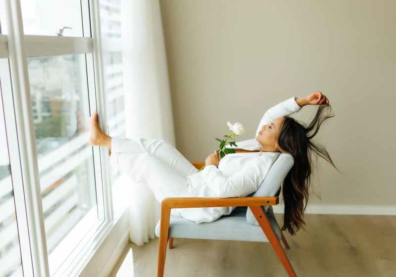 brunette relaxing with rose on chair