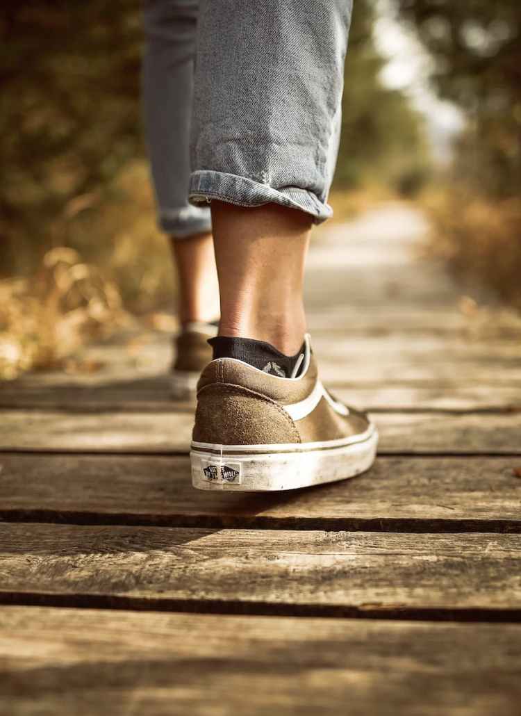 person stands on brown pathway