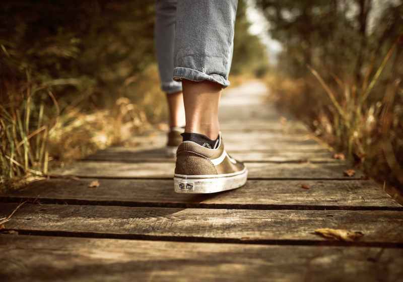 person stands on brown pathway