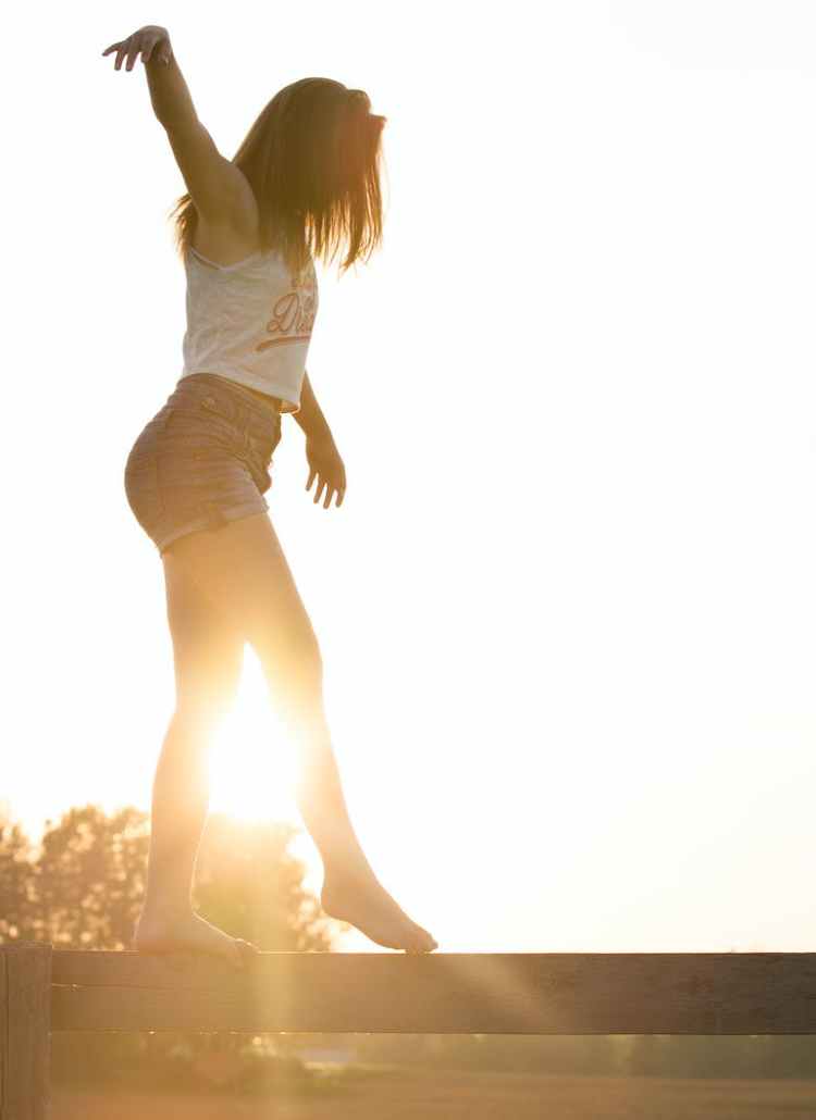 woman walking on fence