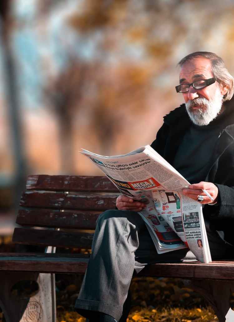 photo of man reading newspaper