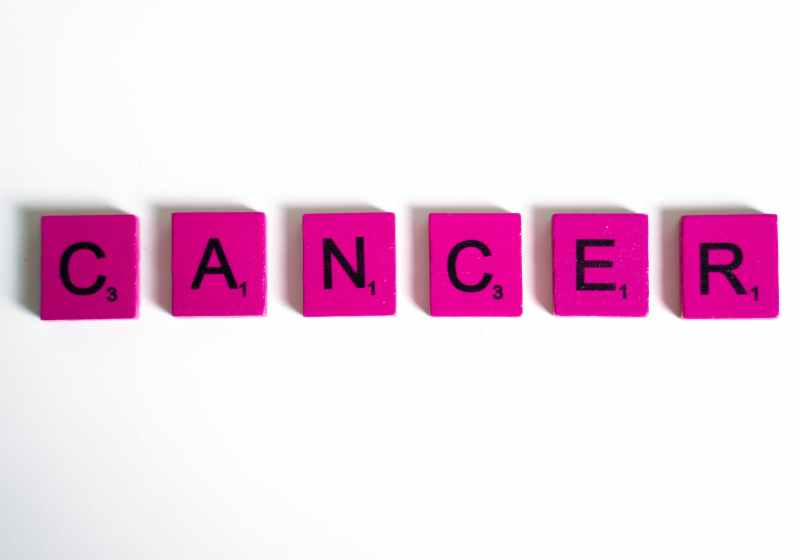 cancer word spelled on scrabble tiles