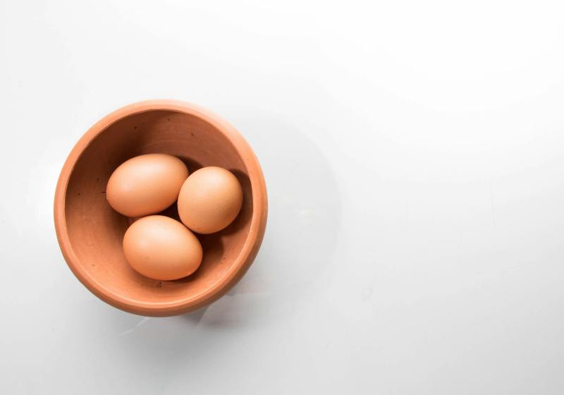 three brown eggs in bowl