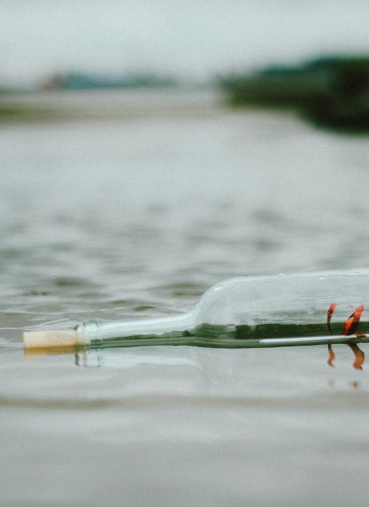selective focus photo of bottle floating on body of water