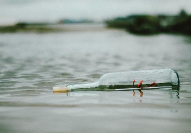 selective focus photo of bottle floating on body of water