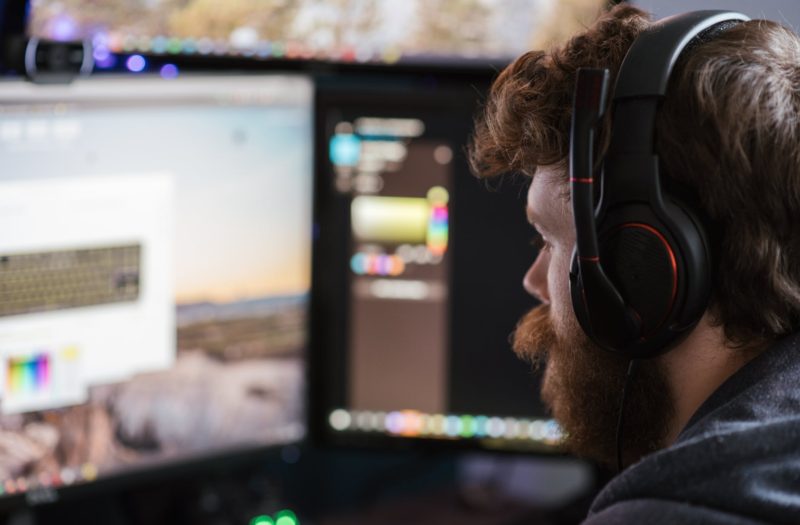 crop man in headphones working on computer