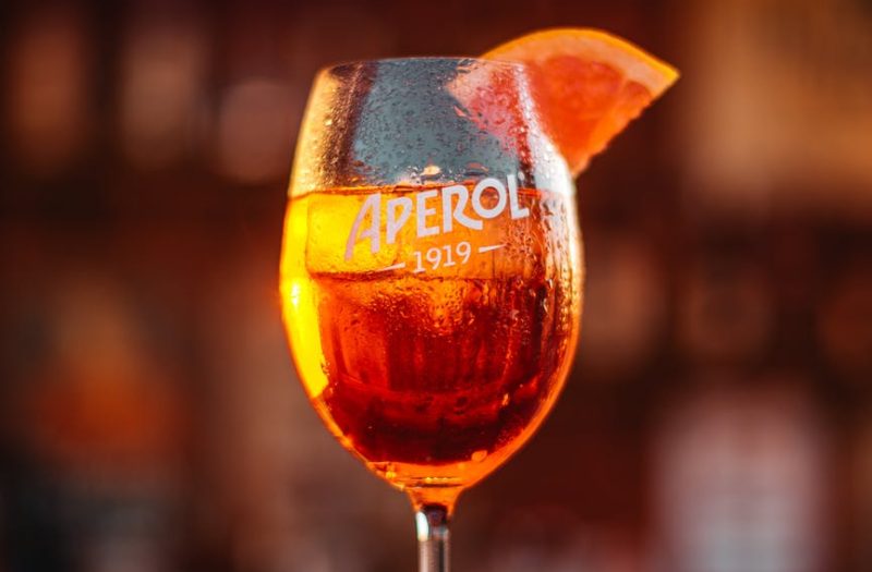 glass of bright alcoholic cocktail on table in pub