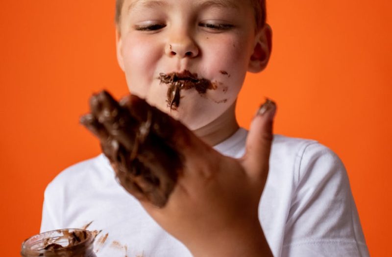 photo of boy enjoying melted chocolate