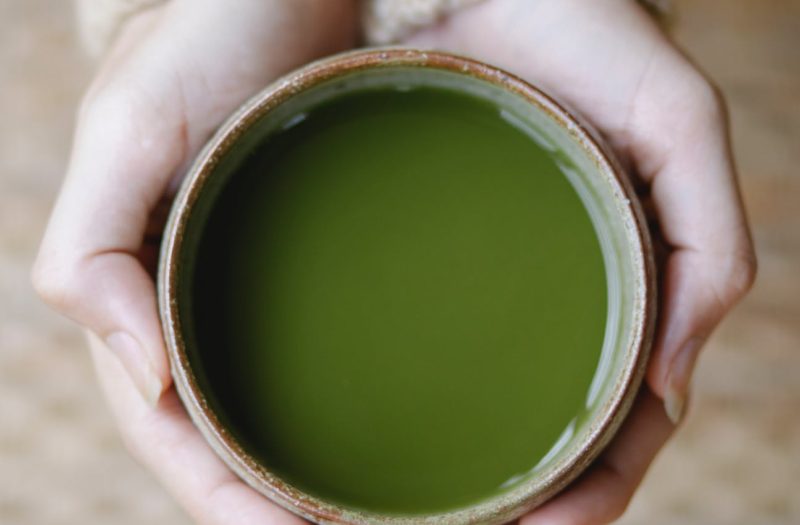 woman demonstrating bowl with traditional green tea