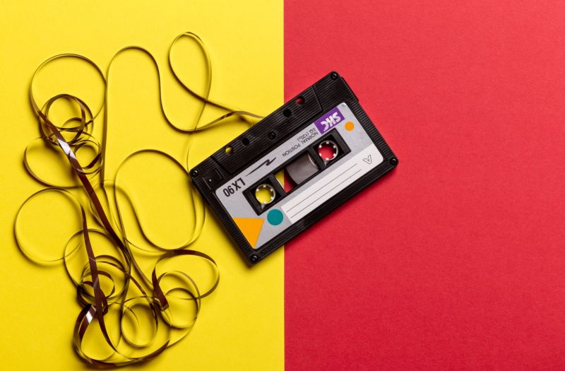 black cassette tape on top of red and yellow surface