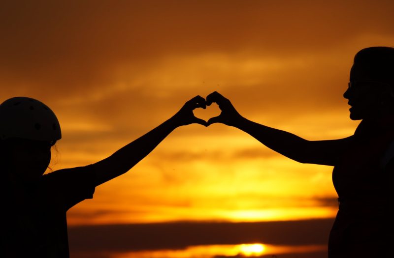 silhouette of man touching woman against sunset sky