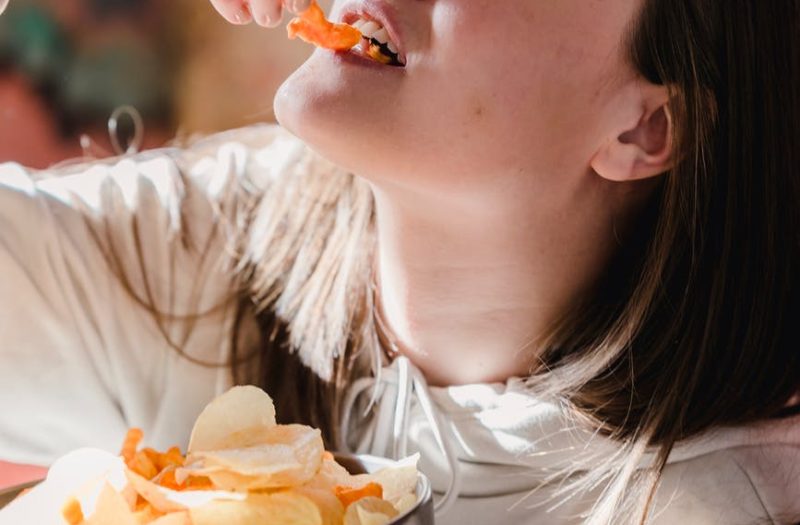 female eating chips at home