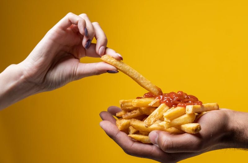 person sharing french fries